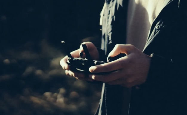 Close-up of an operator's hands on a drone controller.