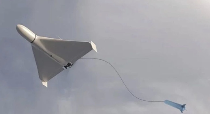 A delta-wing loitering munition in flight against a grey sky.