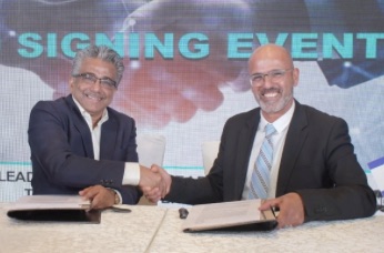 Two executives shaking hands at a technology transfer signing event.